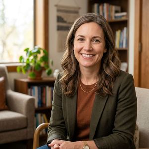 Professional headshot portrait of a caring and approachable licensed clinician in a modern office setting.